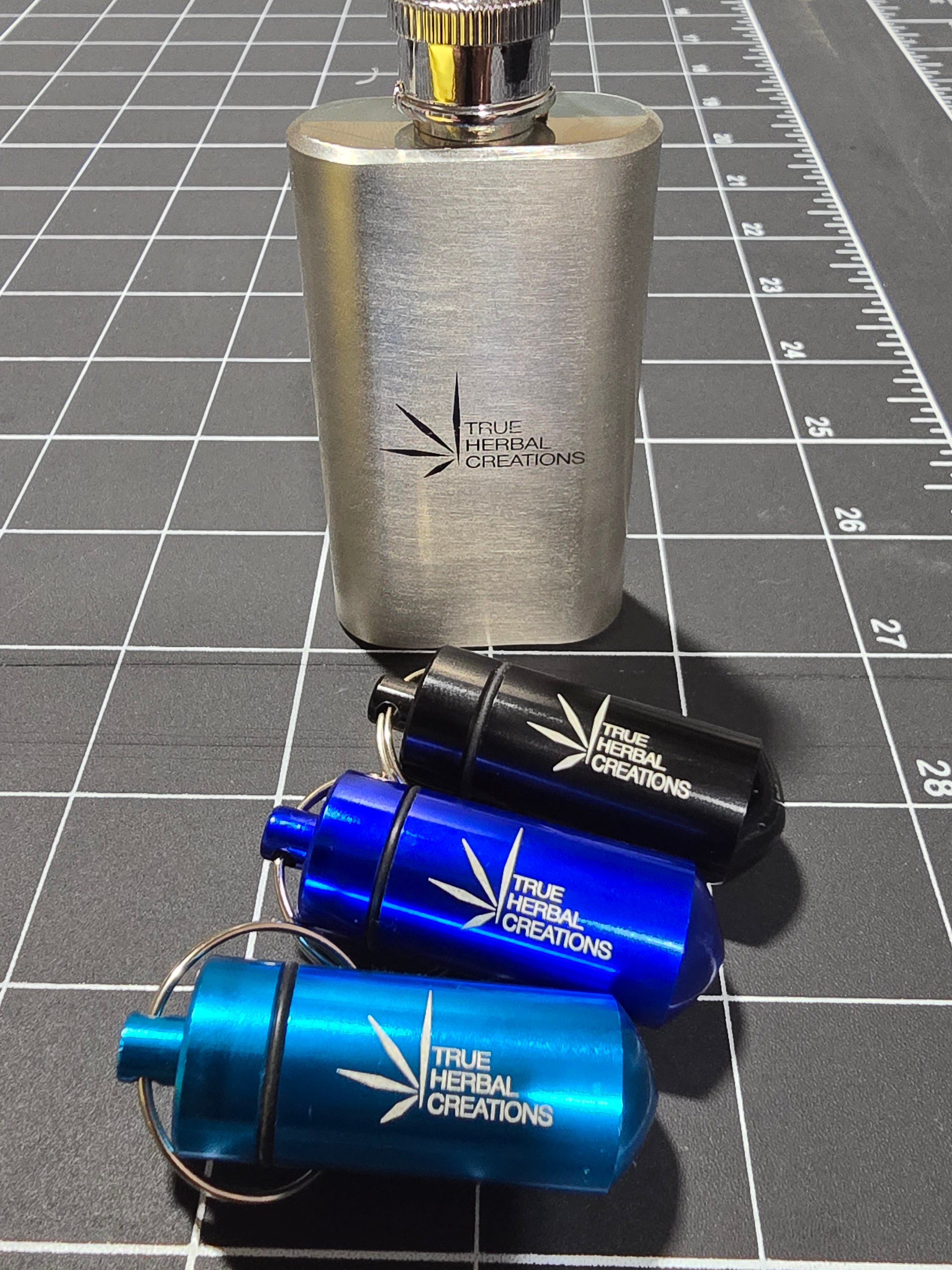 Metal and blue cylindrical containers with branding on a grid background