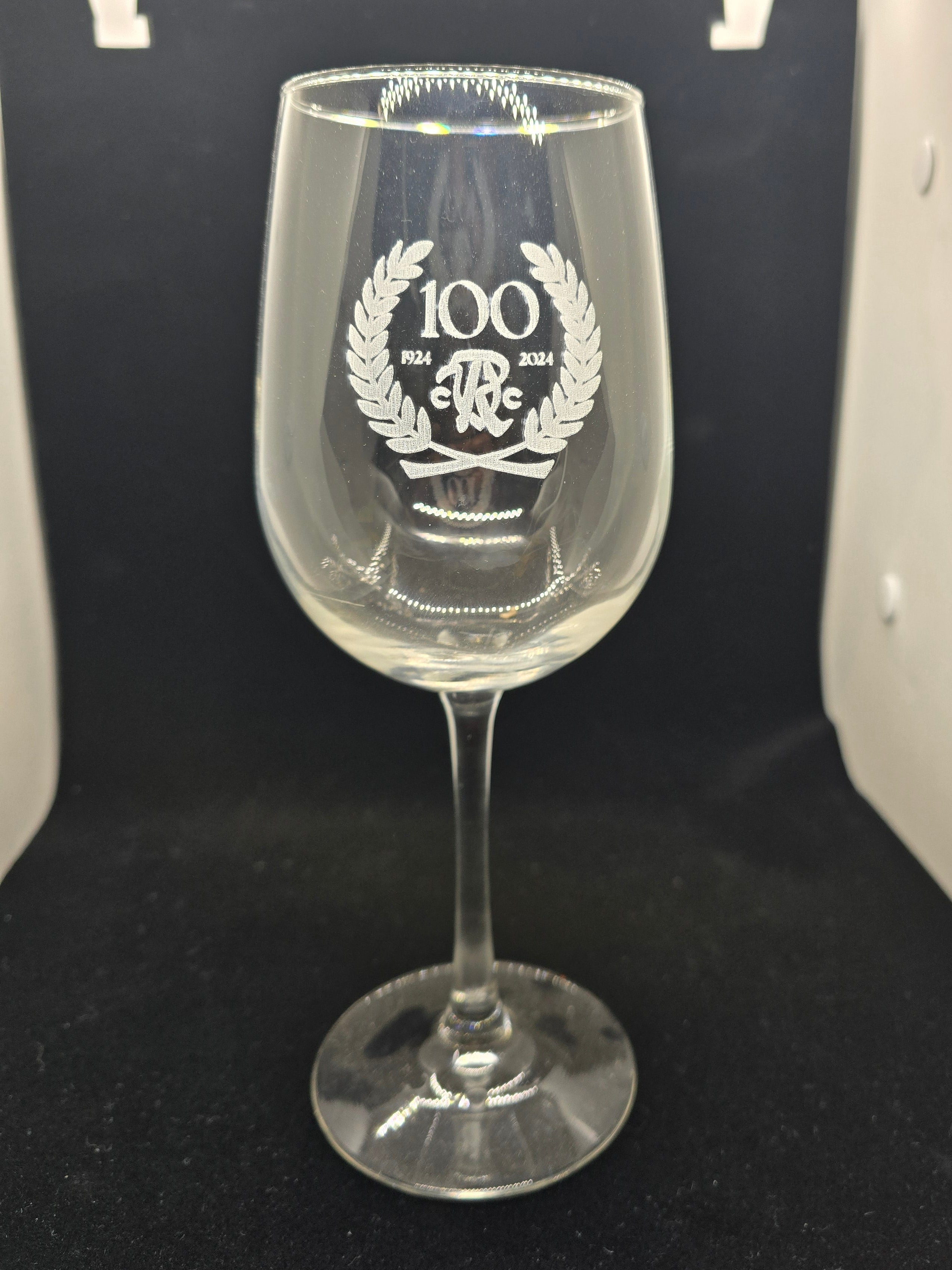 Wine glass with engraved design on a dark surface