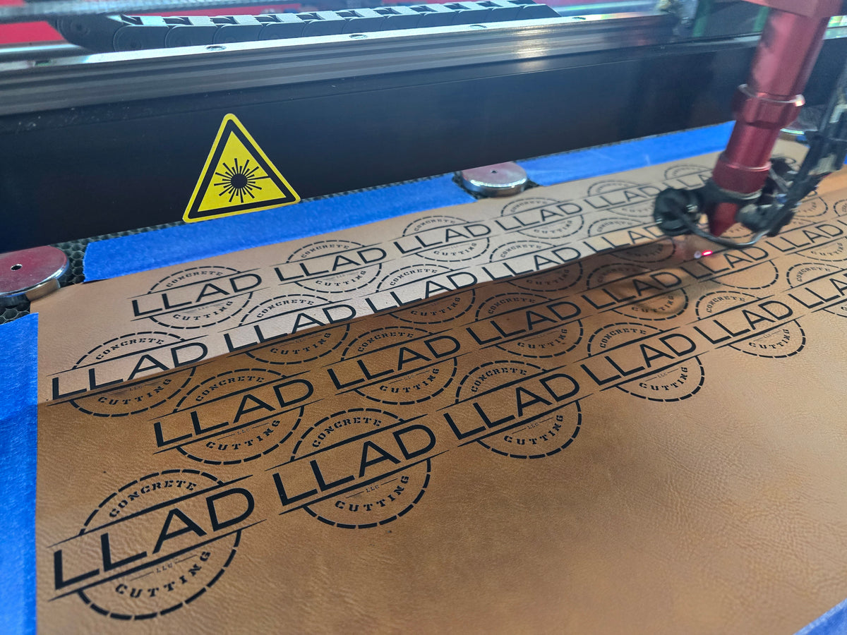 leather with 'LLAD' branding being cut by a laser machine.